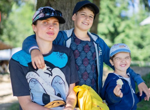 Mother with her two sons having fun outdoors, enjoying a sunny day.